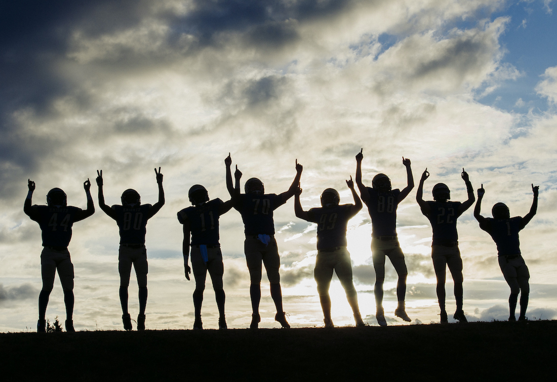 Silhouette of group of young american football players, celebrating