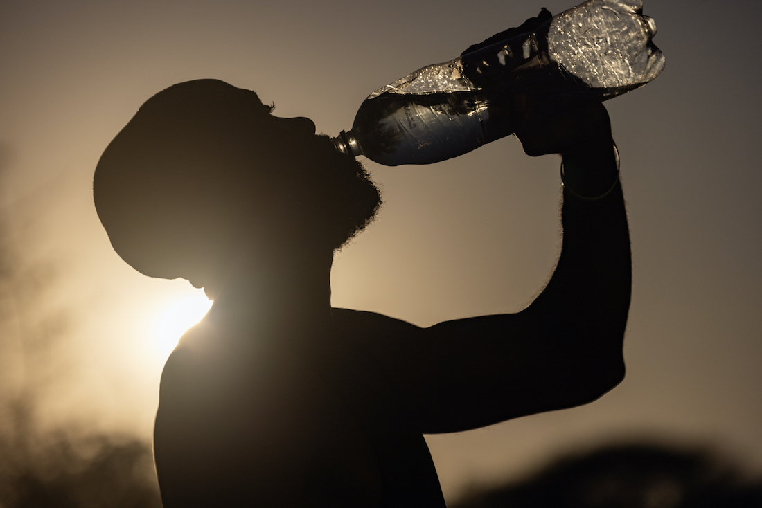 photo of a silhouetted man drinking water