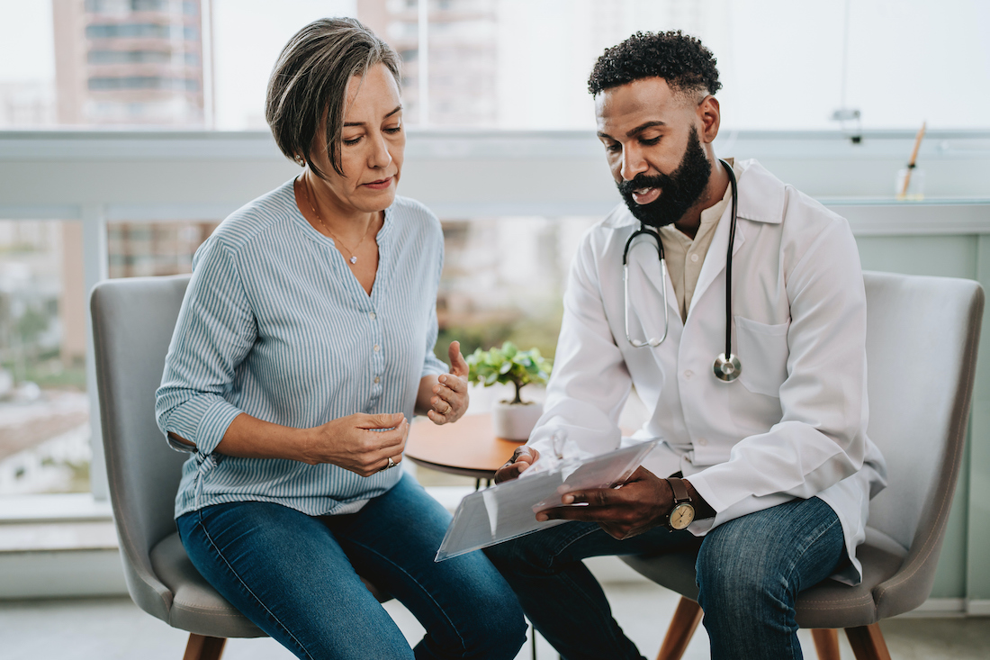 Doctor talking to patient holding clipboard