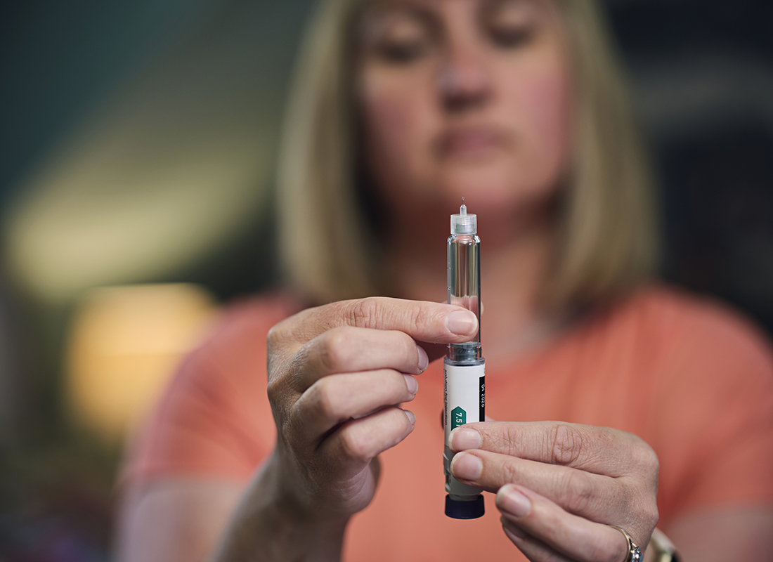 A woman prepares her dose of a weight loss injection using a Semaglutide pen