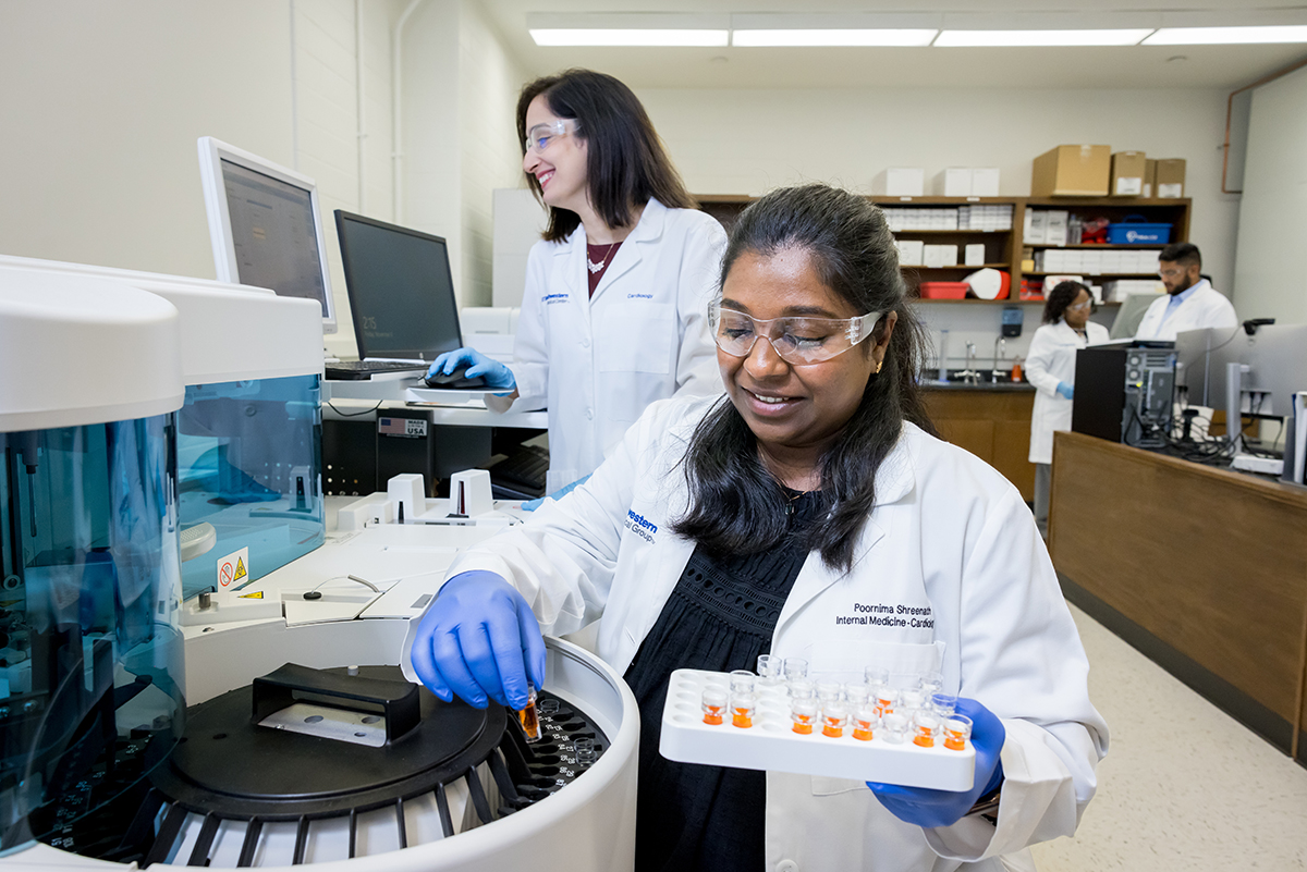 CMRU members in lab setting loading centrifuge